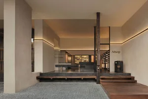 A minimalist retail storefront featuring wood, concrete, and glass materials.