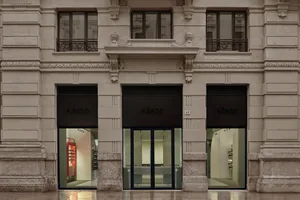 Modern storefront with stone facade and glass doors.