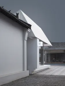 Modern retail storefront with white stone exterior and glass doors.