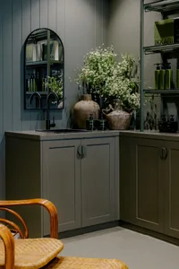 Modern kitchen featuring metallic-textured cabinets and a sink with olive green walls