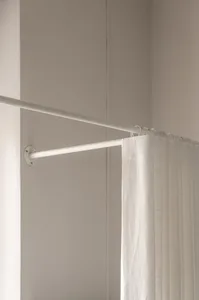 A white curtain on a minimalist rod in a modern living space