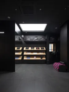 一間時尚現代的零售店，展示衣物於木質層架，並以黑色牆面與素材為特色。
