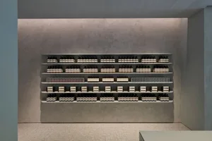 A modern retail store with concrete shelving and tiled floors.