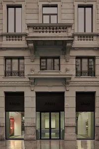 A modern retail storefront with stone, glass, and concrete materials.