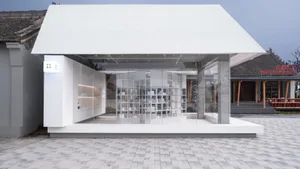 A minimalist storefront with a glass facade and white structural elements.