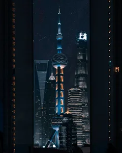 A nighttime cityscape featuring illuminated skyscrapers in Shanghai, China.