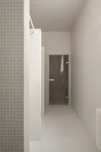 A minimalist bathroom with white tiles and modern design elements.