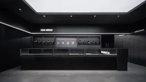A sleek, black minimalist jewelry store with various necklaces displayed on shelves and racks.