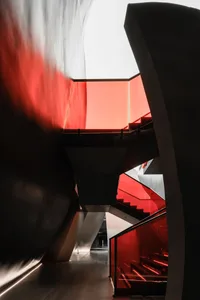 Modern staircase with glass walls and red lighting