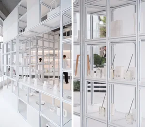 Modern white steel shelves with transparent glass divisions in a retail storefront.