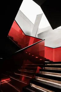 Glass staircase with red accents and a modern design.