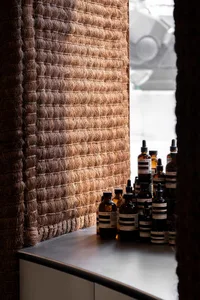 A retail storefront display featuring textured rope and multiple bottles of skincare products.