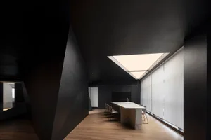 A modern office featuring glass walls and a sleek, minimalist design.