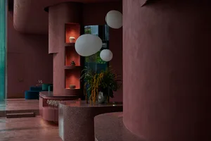 A modern restaurant bar featuring a terrazzo countertop and circular light fixtures.