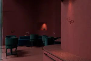 Circular bar area in a modern restaurant with red terrazzo flooring and wooden seating.
