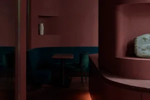 Contemporary restaurant with dark blue velvet seating and marble table surface.