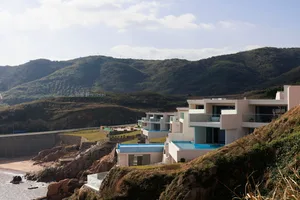 Modern residential holiday home featuring concrete, glass, and metal materials.