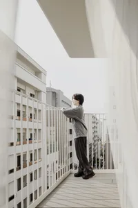 A minimalist balcony with a wooden deck overlooking a cityscape.