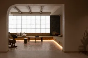 A modern living room with a large window, wooden furniture, and geometric lighting.