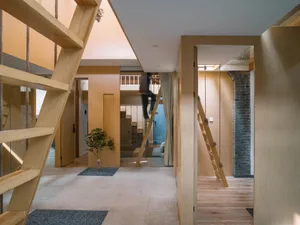 A modern, minimalist interior design featuring a wooden staircase with ropes as handrails.