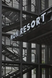 A metal wall sign with the text 'Noa Resort' in an industrial design style.