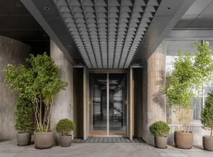 A modern entrance with concrete walls and a glass door.