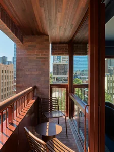 A modern balcony featuring brick walls and metal railings.