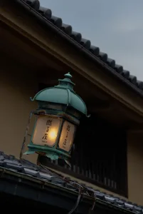 A traditional streetlight made of metal hanging on a roof.