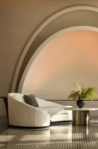 Modern minimalist living room interior with neutral color palette and arch-shaped ceiling feature.