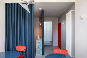 Modern dining room featuring blue fabric seating and a blue table.