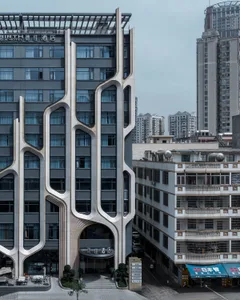 Modern hotel exterior featuring concrete and glass materials.
