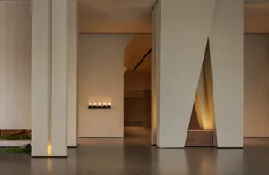 Modern interior space featuring concrete walls and wooden elements with minimalist lighting design.