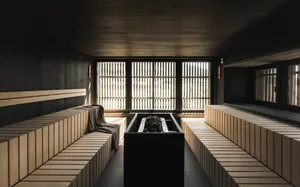 Modern wooden sauna interior with stone floor and rock sauna heater