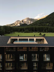 Modern hotel room with black wood walls and a glass area overlooking mountains