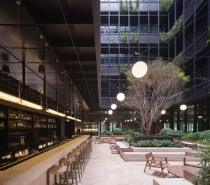 A modern corporate office with glass walls, concrete floors, and wooden furniture.