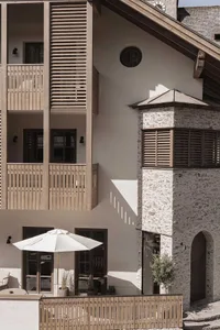 Modern residential exterior featuring wooden balconies and stone accents.