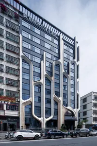 Modern building exterior featuring concrete and glass materials in an urban setting.