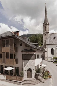 A picturesque village center featuring stone buildings, wooden balconies, and metallic accents.