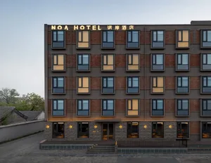 Modern hotel building with brickclad exterior and illuminated windows during dusk