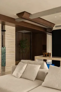 A modern living room featuring elegant wood textures and minimalist design. Includes a comfortable beige sofa with plush cush