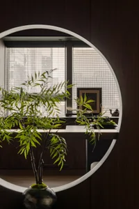 A circular frame showcasing a window sill arrangement with greenery and decor.