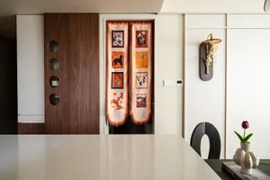 View of a minimalist kitchen featuring an orange printed door with various decorative patches.