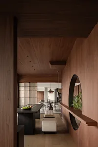 A modern dining room featuring wooden walls, a sleek dining table with a geometric centerpiece, and modern lighting fixtures.