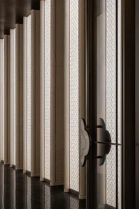 Modern interior design featuring elegant glass columns with intricate geometric patterns.
