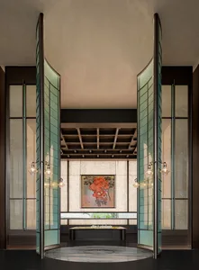 A modern lobby with large glass doors and a painting on the wall.
