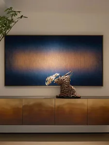 Modern living room featuring a metallic console with a cloud-like abstract sculpture on top and a large abstract painting on 