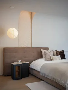 Modern minimalist bedroom featuring plush velvet bedding, marble nightstand, and wooden accents, showcasing sophisticated des