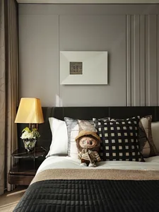 Bedroom with modern brown leather headboard, white and brown bedding, and decorative pillows.