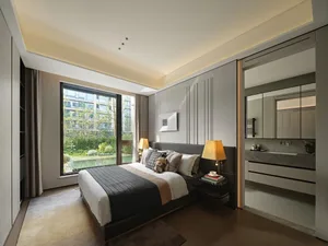 Modern bedroom with wood flooring, featuring a large window overlooking a garden and a comfortable bed with a black headboard