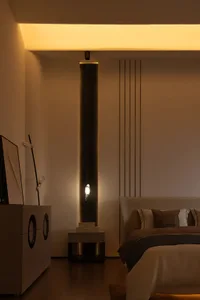 Photograph of a modern contemporary bedroom featuring a sleek, minimalist metal nightstand with an elevated pedestal base.